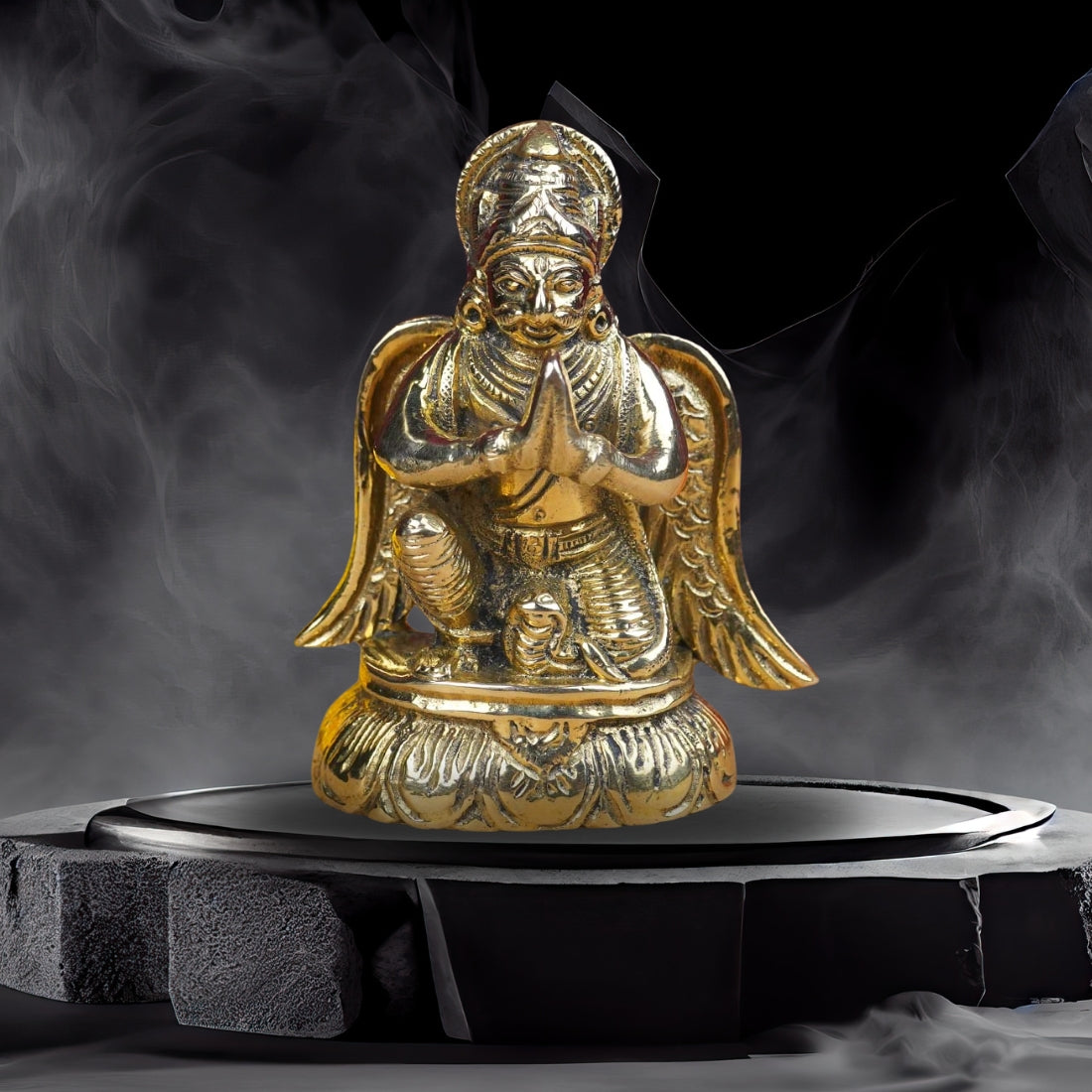 Brass Lord Garud Dev Ji idol displayed on a dark pedestal with incense smoke