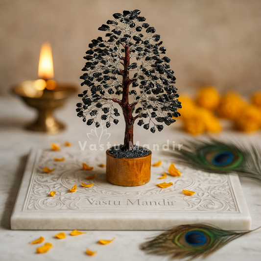 Black Tourmaline Vastu Tree (10-11  Inch) for protection, grounding, and negative energy absorption. on a marble slab with 'Vastu Mandir' branding, surrounded by peacock feathers and a lit candle.