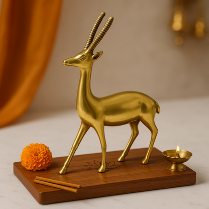 Gold deer figurine on a wooden base with a candle and marigold flower against a warm background