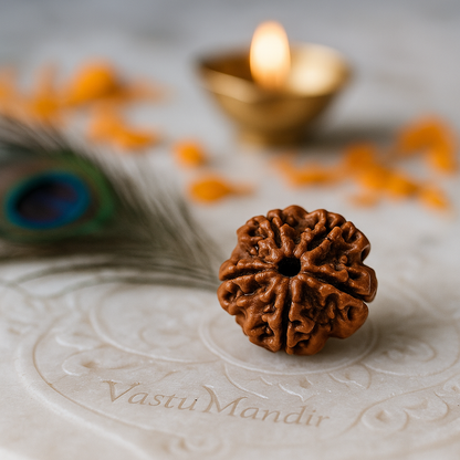 4 faced Brown rudraksha bead on a decorative marble with a lit candle in the background