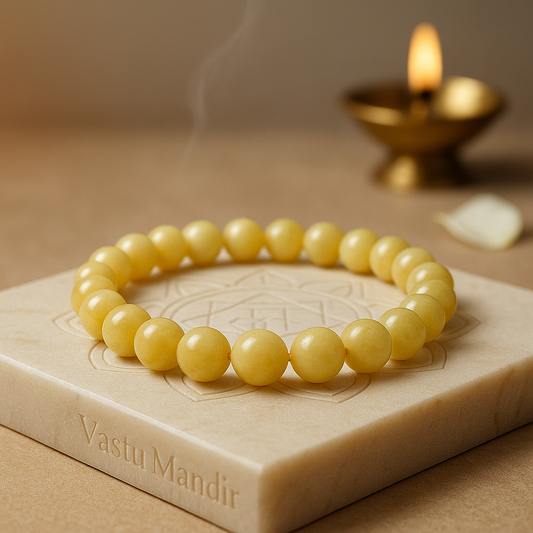 Yellow Calcite 8mm bead bracelet on a stone surface with a candle in the background