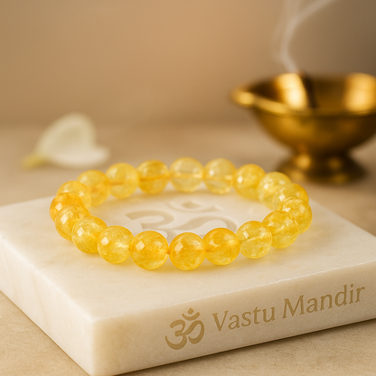 Yellow beaded bracelet on a white stone with 'Vastu Mandir' branding.