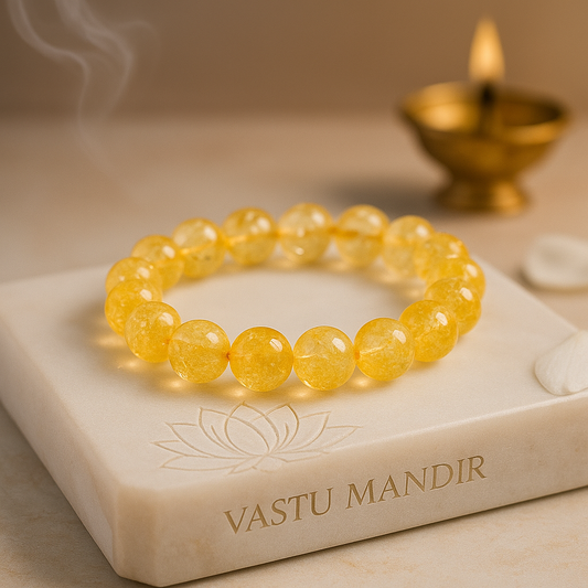 Citrine 10mm bead bracelet on a marble stand with 'Vastu Mandir' branding, lit candle in the background