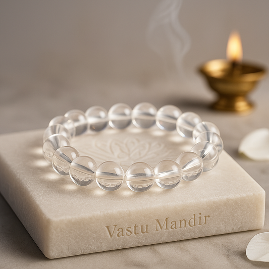 clear quartz 8mm bead bracelet on a marble surface with 'Vastu Mandir' branding, candle in the background