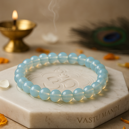 opalite 8mm bead bracelet on a marble base with decorative elements in the background