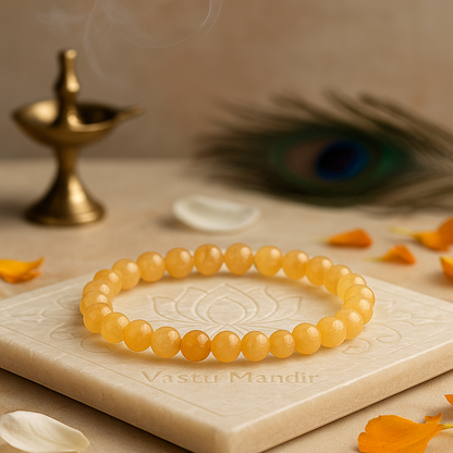 Rutile quartz 8mm bead bracelet on a decorative stone surface with a peacock feather and oil lamp in the background.