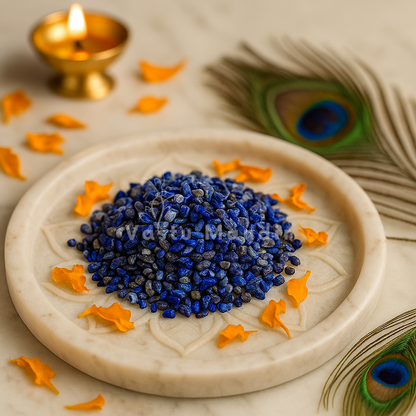 Lapis Lazuli Crystal Chips, orange petals, and peacock feathers on a light background