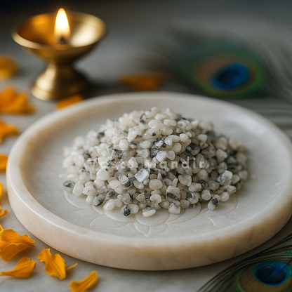 Decorative plate with Natural Moonstone Chips, peacock feathers, and a lit candle on a light background