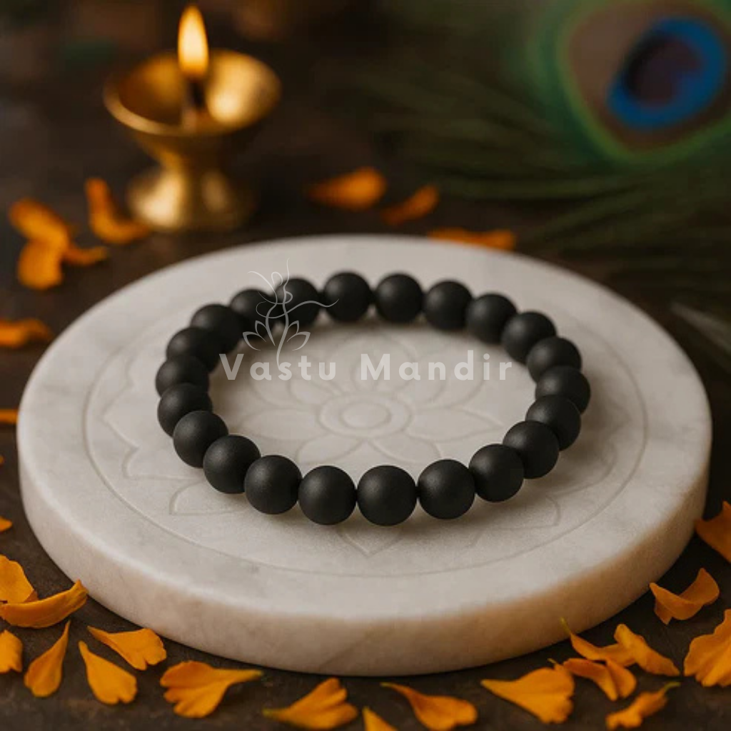 100% Natural Sulemani beads with distinctive black color and natural banding patterns with 'Vastu Mandir' branding, surrounded by decorative elements.