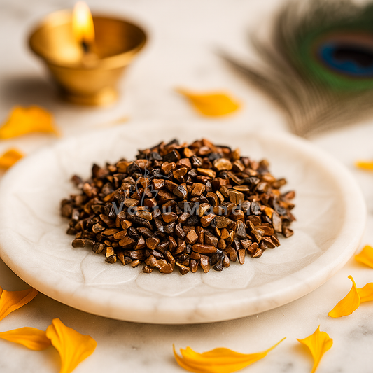 Marble plate with Grounding Tiger Eye Energy Chips, gold diya, and peacock feather on a light background