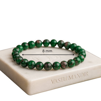 Green ruby zoisite 8mm bead bracelet on a white marble stand with 'Vastu Mandir' branding