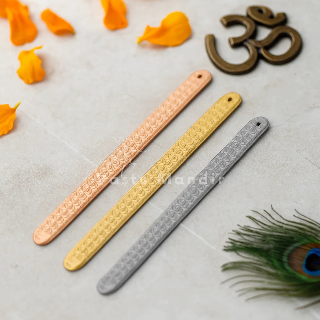 Pyramid Strip 10.5" for Vastu Remedy in Copper, Brass, and Lead on a light gray background with peacock feathers and orange flower petals.