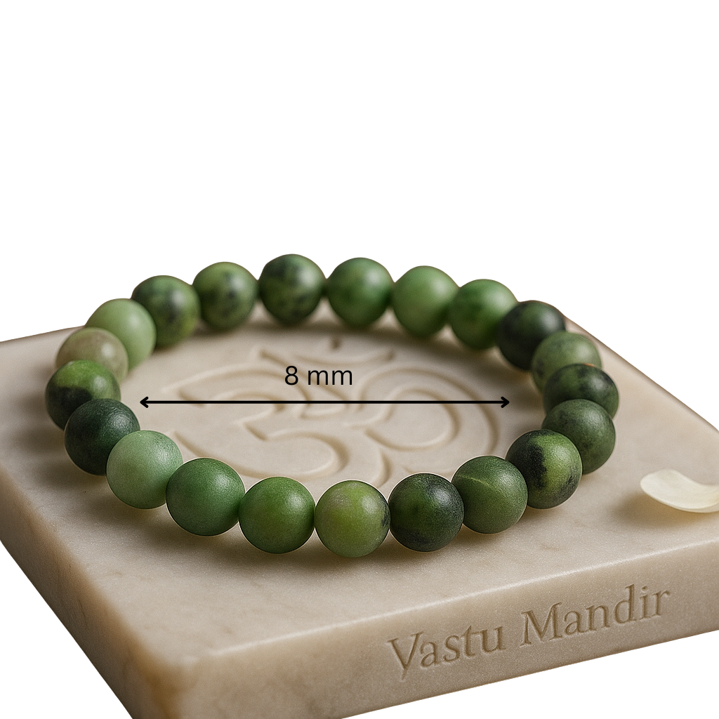 Green beaded bracelet on a stone surface with 'Vastu Mandir' branding