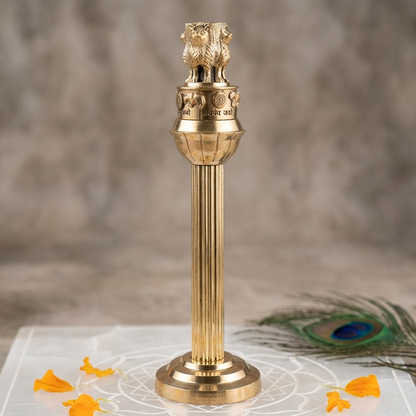 Ashoka Pillar with lion heads on top, placed on a white surface with 'Vastu Mandir' branding.