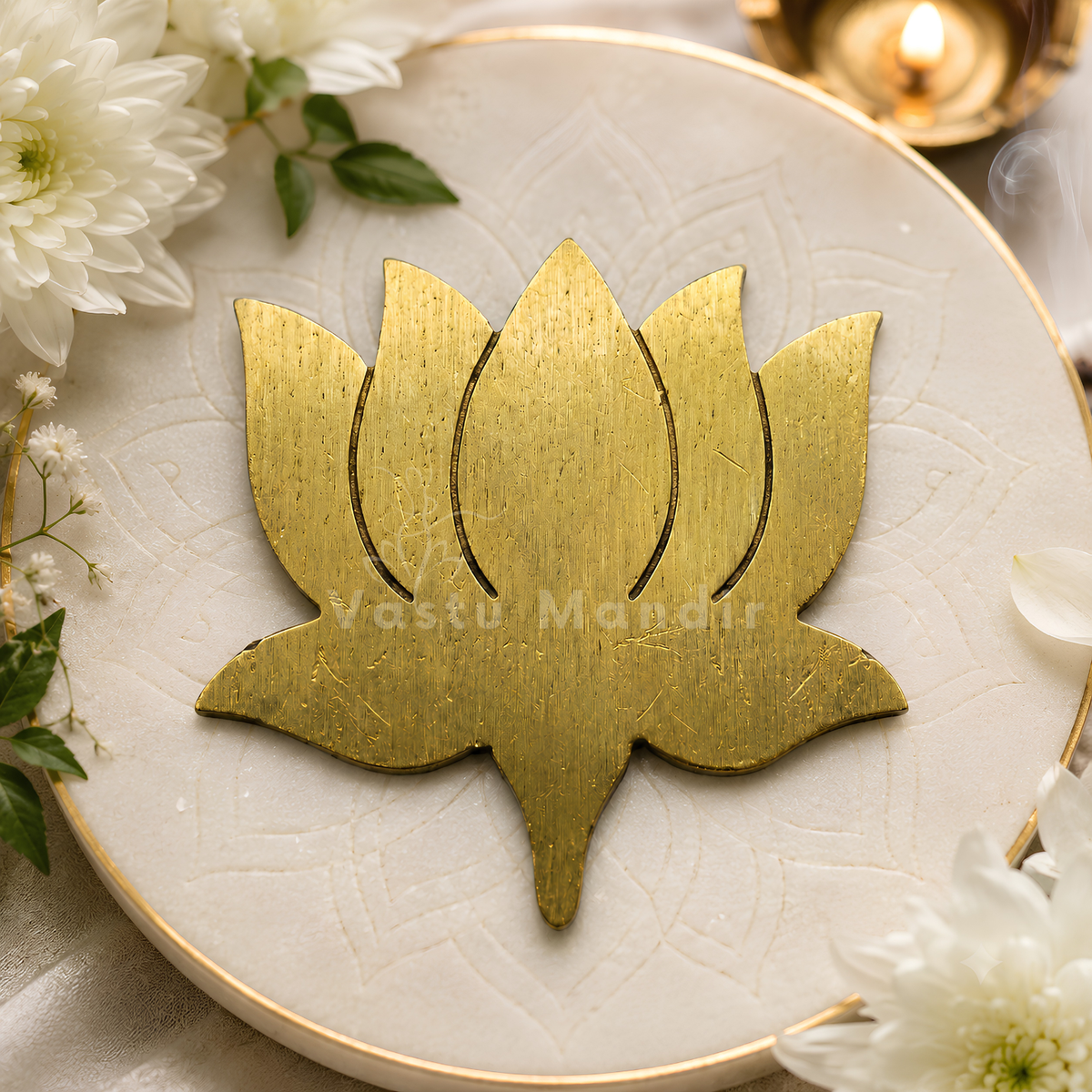 Brass lotus with brushed metallic petals on a white plate with flowers