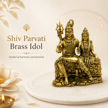 Brass statue of Shiv Parvati on a white platform with decorative elements