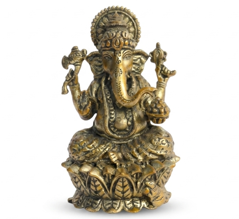 Ganesha idol made of brass on a lotus base against a white backdrop