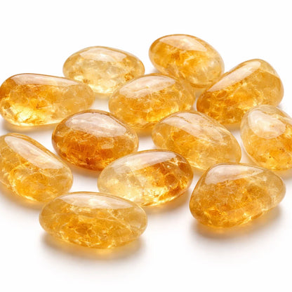 Close-up of citrine tumbled stones on a clean white background showing natural colour and texture