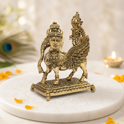 Flying Kamdhenu cow brass idol on a white surface with a softly blurred background