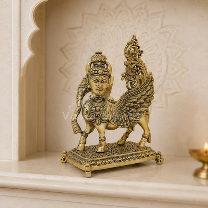 Flying Kamdhenu cow brass idol displayed on a white shelf in a neutral interior