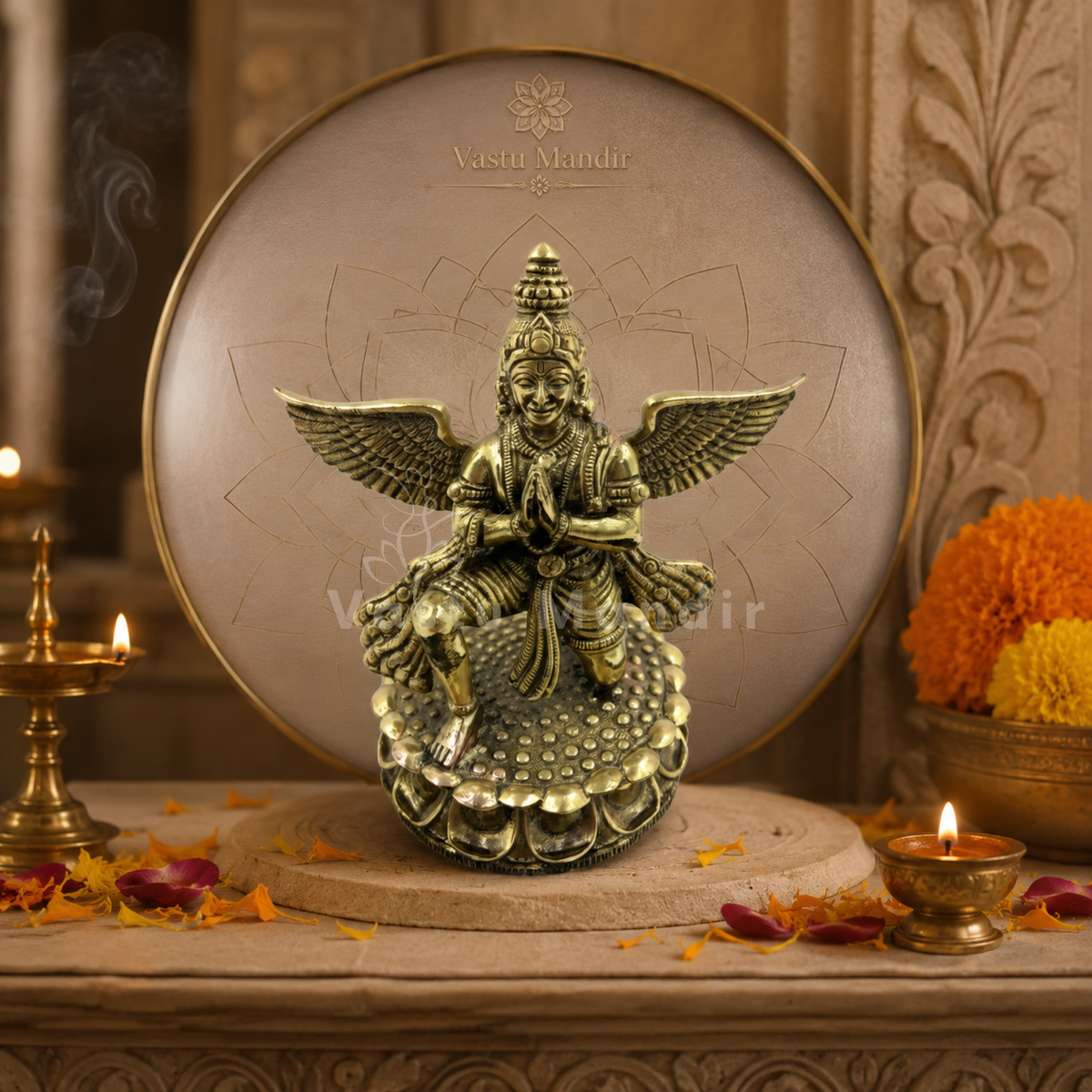 Garud Dev brass idol on a circular platform surrounded by candles and flowers