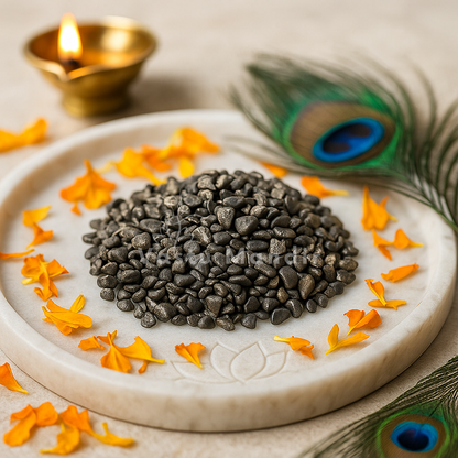 Natural Hematite Chips on a white plate with orange flowers and peacock feathers, accompanied by a lit Diwali lamp.