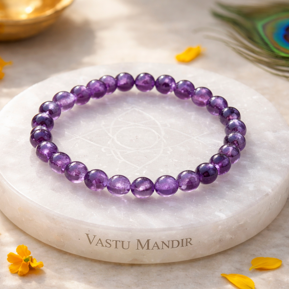 Hydro Amethyst Bracelet on a white marble coaster with 'Vastu Mandir' branding, surrounded by yellow flowers.