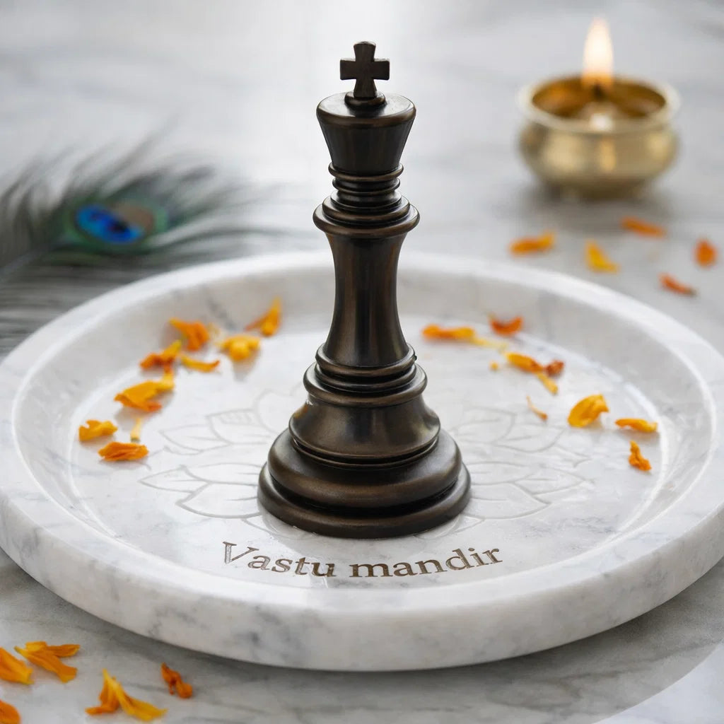 Resin King Chess Piece on a marble platter with 'Vastu mandir' branding, surrounded by yellow flowers and a lit candle.
