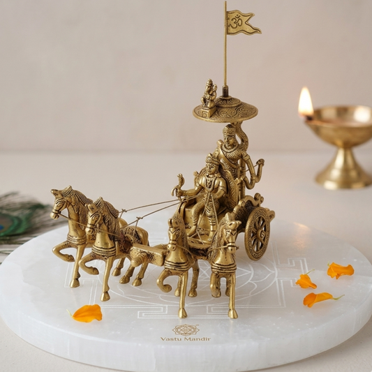 Brass chariot sculpture with horses on a white base, featuring a brand logo.