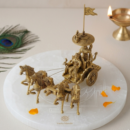 Brass chariot sculpture on a white platform with decorative elements