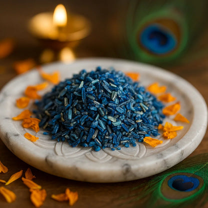 Kyanite Chips on a white plate with peacock feathers and a candle in the background