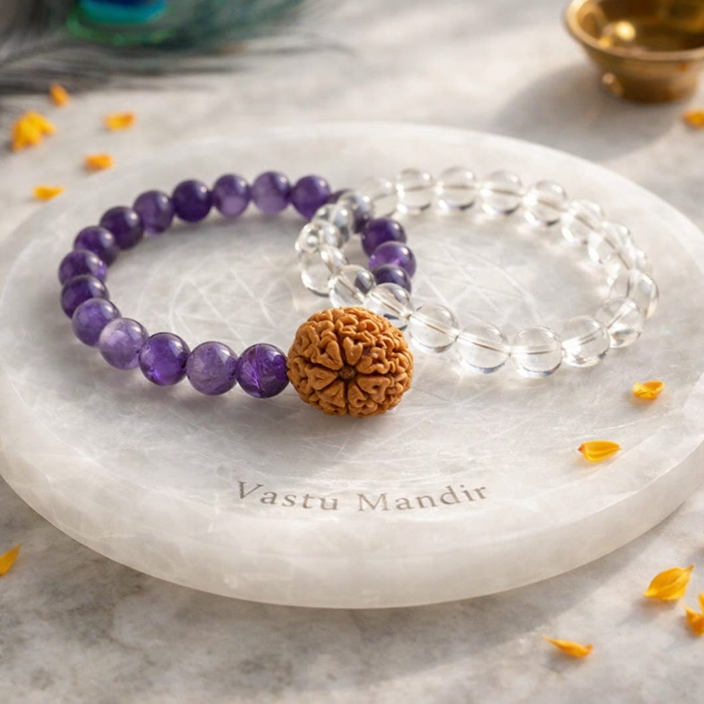 Amethyst and Clear Quartz bracelets with 7 Mukhi Rudraksha on a marble stone with 'Vastu Mandir' engraving.