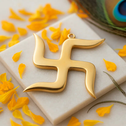 Brass swastika Vastu remedy on a white stone surface with yellow petals and a spool of thread in the background.
