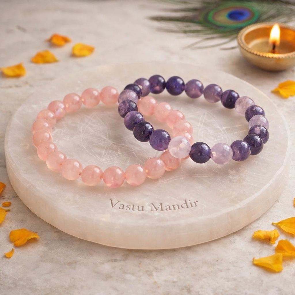 Rose quartz and amethyst bracelets styled with traditional diya lamp, marigold flowers, peacock feathers on marble surface - Vastu Mandir emotional healing jewelry
