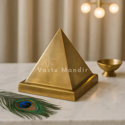 Solid Brass Pyramid with 'Vastu Mandir' branding on a marble surface with a peacock feather.