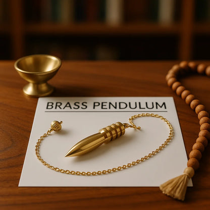 Vastu Brass pendulum on a piece of paper with 'BRASS PENDULUM' text, surrounded by wooden beads on a wooden surface.