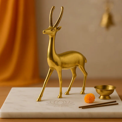 Gold deer figurine on a marble surface with a blurred background