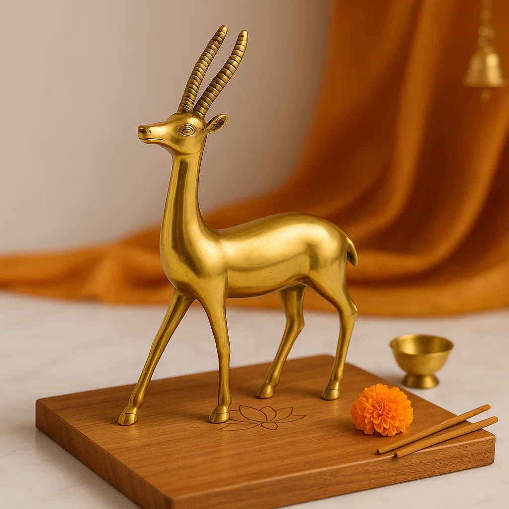Gold deer figurine on a wooden base with orange fabric in the background
