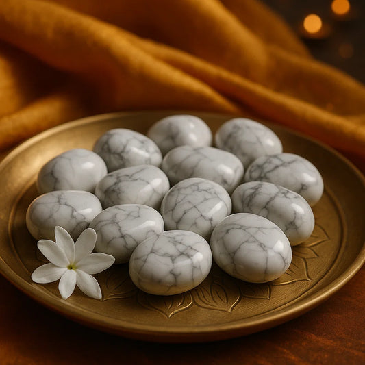 Marble stones on a decorative plate with a white flower on a warm-toned fabric background. Polished howlite crystals for peace and spiritual awareness