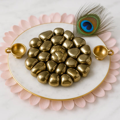 Gold heart-shaped objects on a marble plate with peacock feather