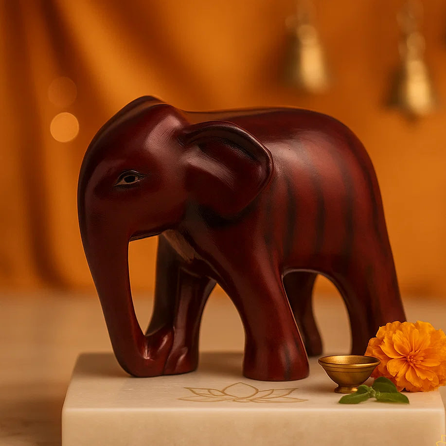 vastu Brown elephant figurine on a white base with decorative elements against an orange background