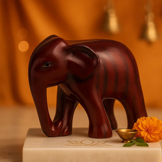 vastu Brown elephant figurine on a white base with decorative elements against an orange background