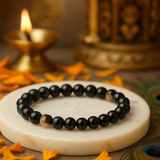 Black Agate 8mm bead bracelet on a marble surface with decorative elements in the background