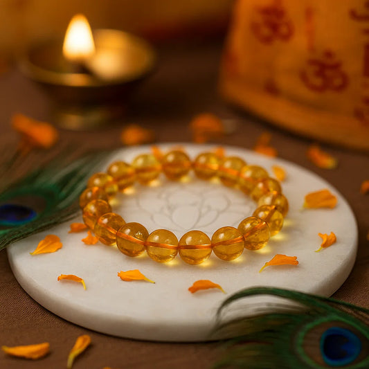 Citrine 10mm bead bracelet on a white stone surface with decorative elements and a blurred background.