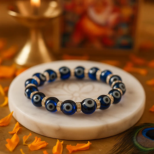 Blue evil eye bracelet 10mm beads on a marble coaster with decorative elements.