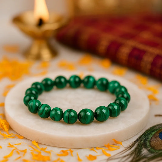 Natural green jade bracelet on a marble coaster with decorative elements in the background