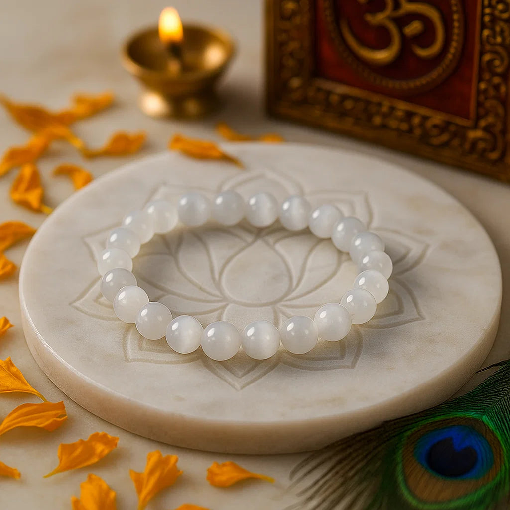 Natural selenite 8mm crystal bead bracelet on a marble surface with decorative elements