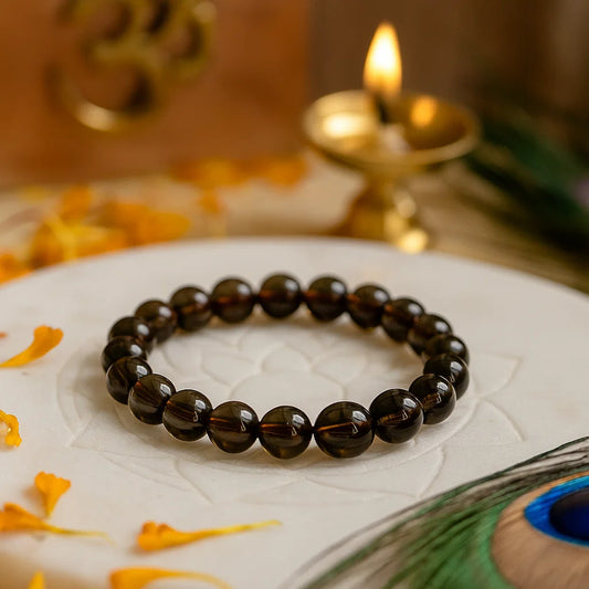premium smoky brown quartz bracelet on a white surface with decorative elements in the background