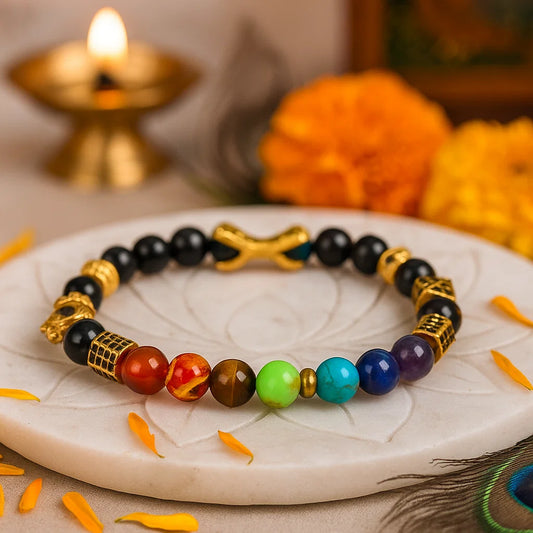 7 chakra destiny claw mala style 8mm beads bracelet on a white plate with flowers and a candle in the background