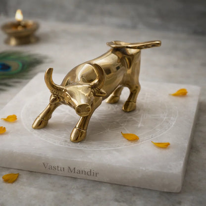 Brass bull figurine on a Selenite slab with 'Vastu Mandir' branding with decorative elements.